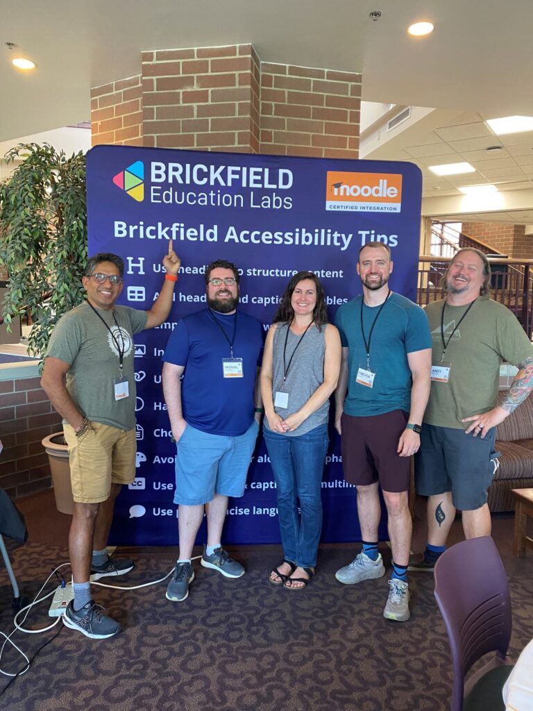The OpenLMS team standing in front of our Brickfield Accessibility Tips banner.